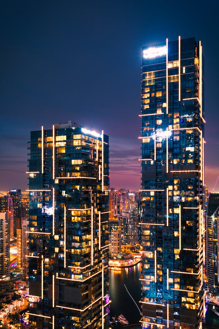 Stunning night view of Dubai's illuminated skyscrapers with vibrant city lights reflecting in the marina.